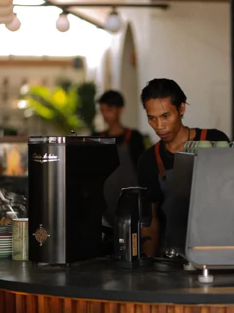 Barista menyiapkan kopi di balik bar