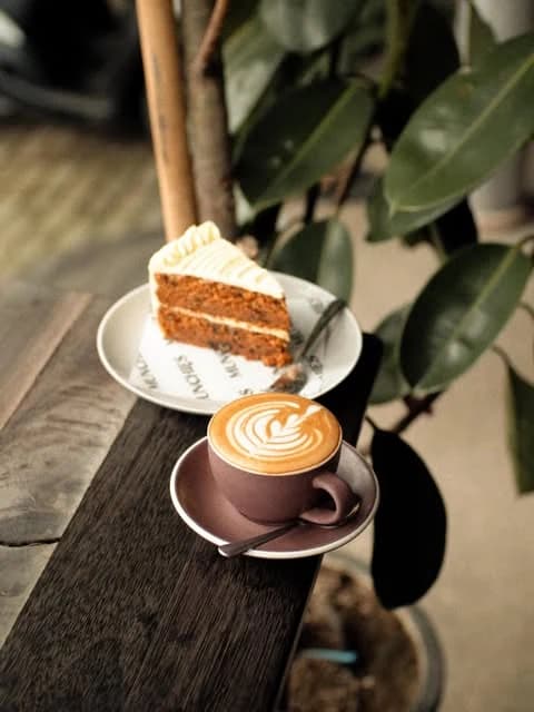 Carrot cake dan latte art di meja kayu