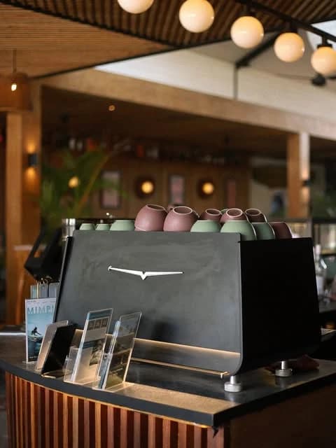 Mesin espresso dan cangkir keramik di bar